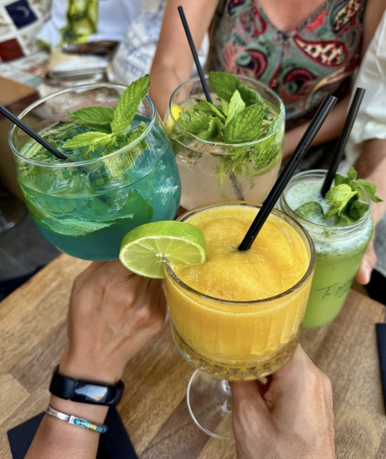 Friends toasting with colorful cocktails